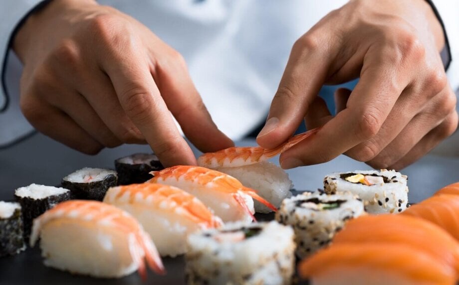 mężczyzna przyrządza sushi