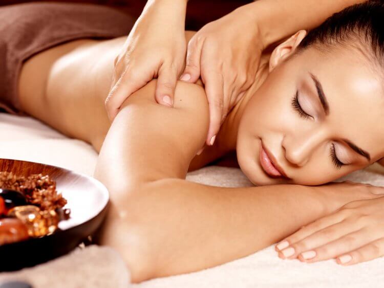Zrelaksowana kobieta podczas masażu w salonie SPA