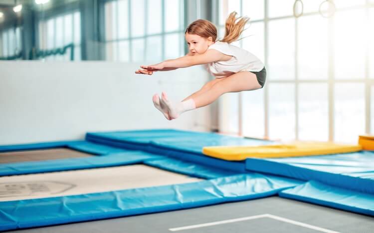 dziewczynka skacze na trampolinach