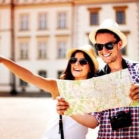 uśmiechnięta para zwiedza miasto z mapą