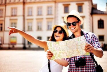 uśmiechnięta para zwiedza miasto z mapą