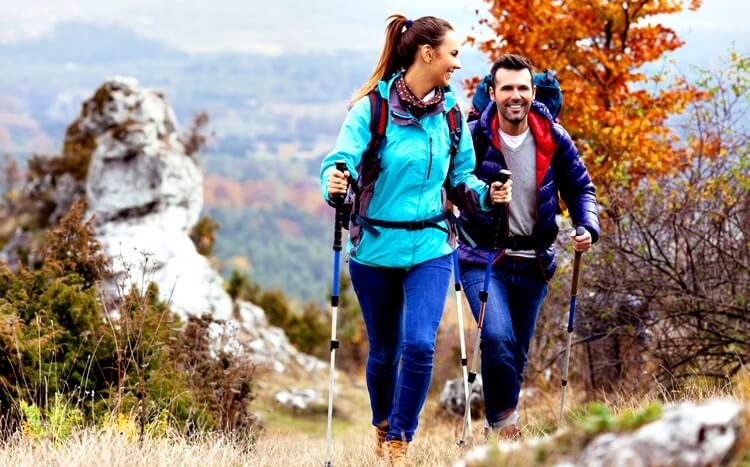 para uprawia nordic walking jesienią w górach