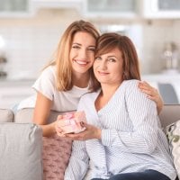 mama i córka na kanapie trzymają prezent