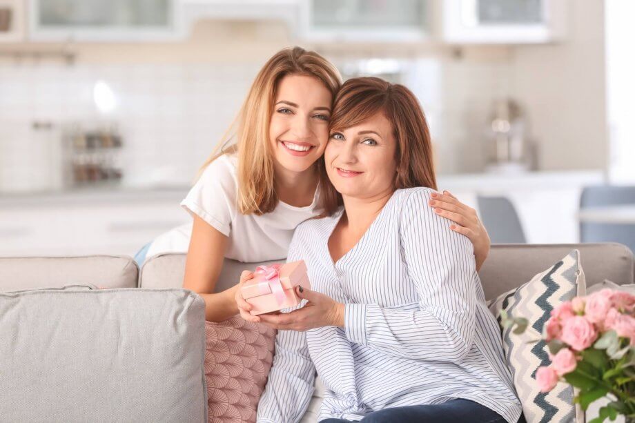 mama i córka na kanapie trzymają prezent