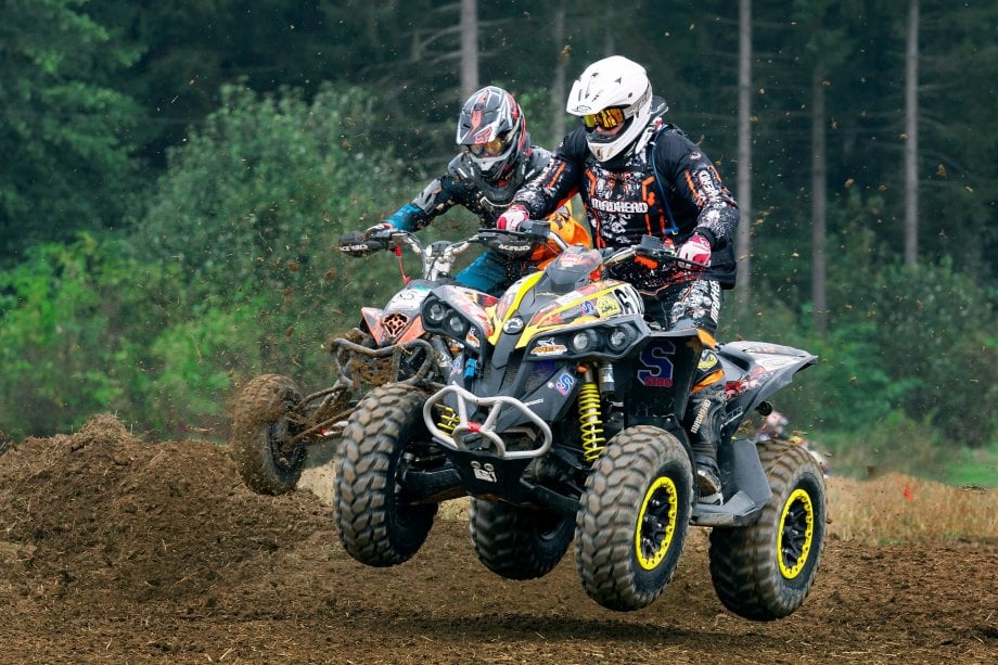 dwie osoby jadą na quadach po lesie