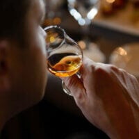 Mężczyzna wąchający whisky w szklance