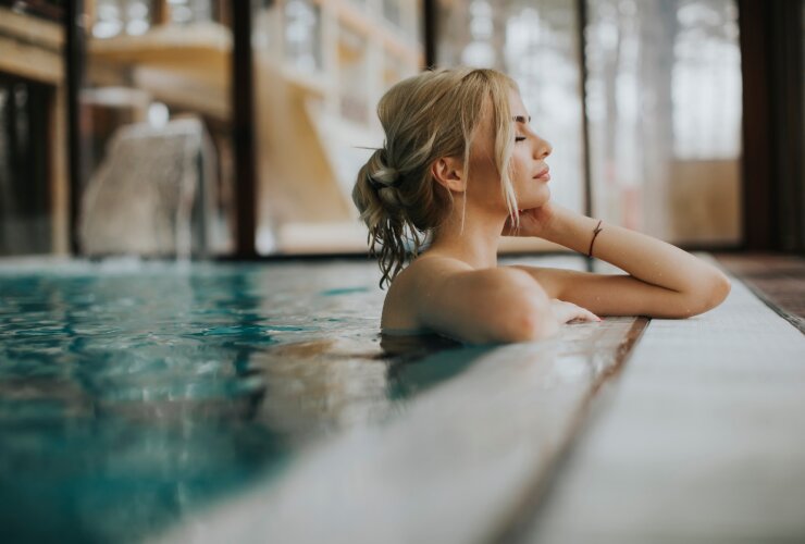 Młoda kobieta o blond włosach relaksuje się w basenie SPA