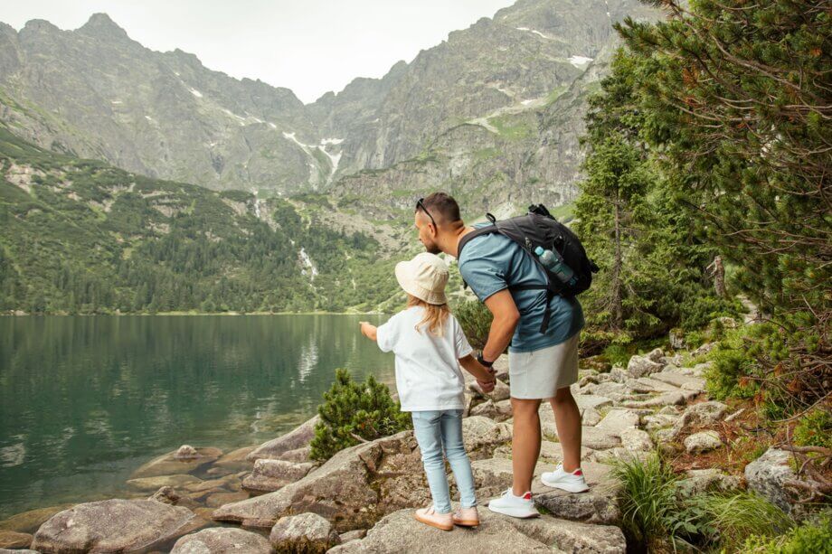 Dziewczynka wskazująca palcem na Morskie Oko i tata trzymający ją za rękę