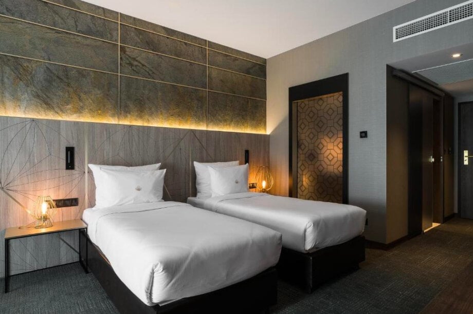 dwa łóżka w pokoju hotelowym