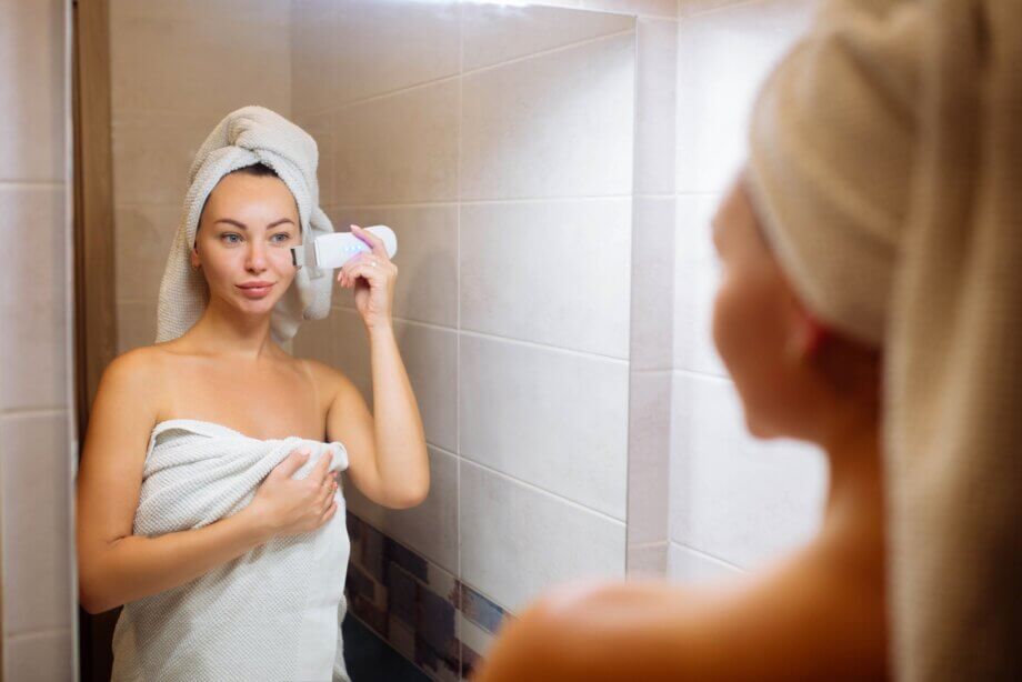 Kobieta wykonująca peeling kawitacyjny sama sobie w domu