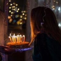 Dziewczyna zdmuchująca świeczki na torcie
