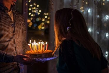 Dziewczyna zdmuchująca świeczki na torcie