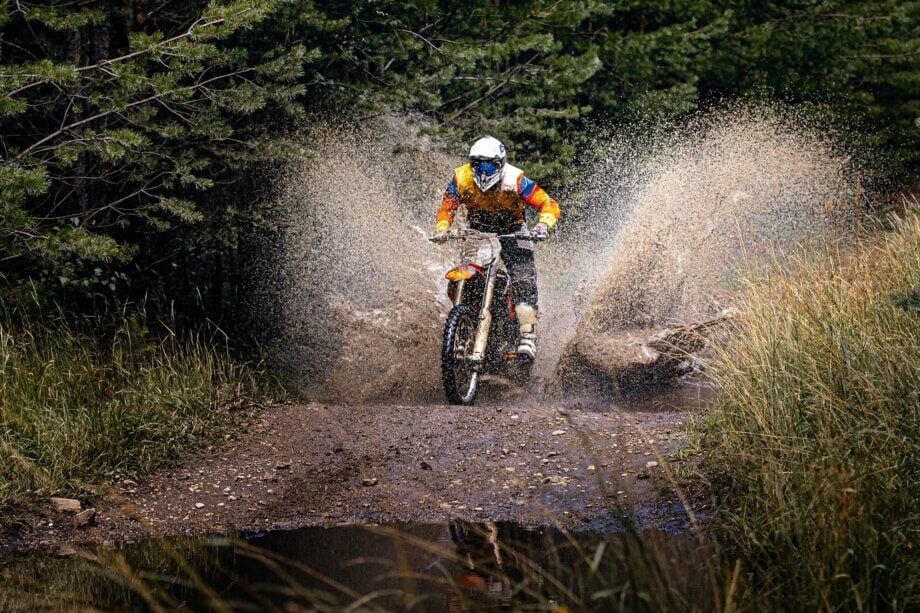 Kierowca enduro jedzie po wodzie